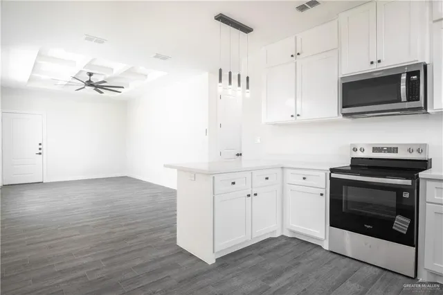 a kitchen with stainless steel appliances white cabinets and wooden floor
