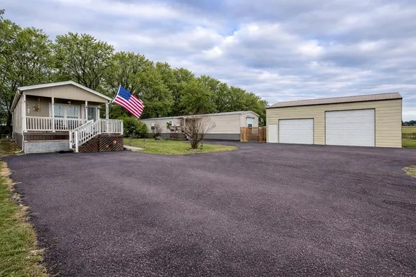 a view of a house with a yard and sitting area
