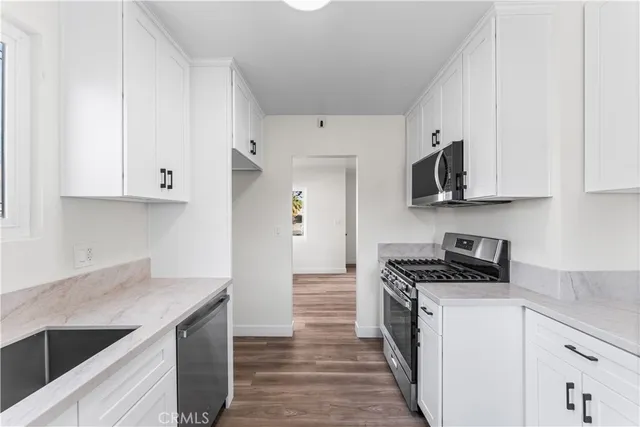 a kitchen with stainless steel appliances a white stove top oven and cabinets