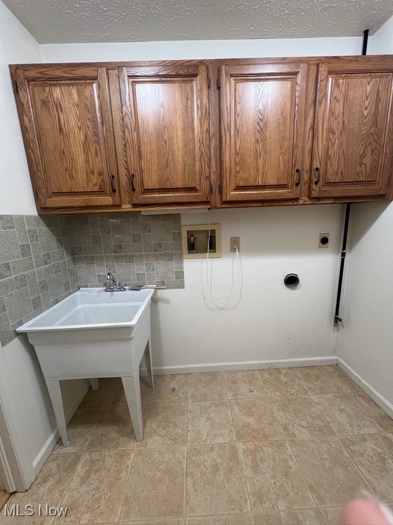 11331 Palmer Road Painesville, OH 44077 - Photo 40 of 47 Laundry room featuring light tile patterned flooring, washer hookup, hookup for an electric dryer, and cabinets