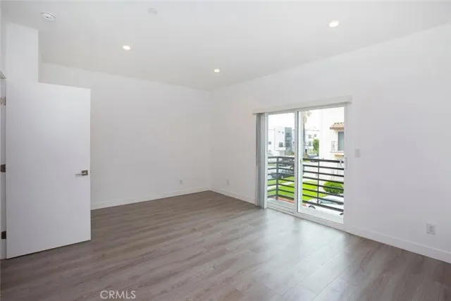 an empty room with wooden floor and a window