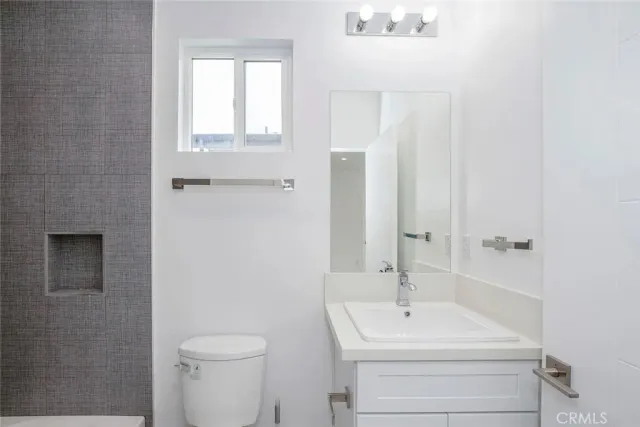 a bathroom with a sink a toilet and a mirror