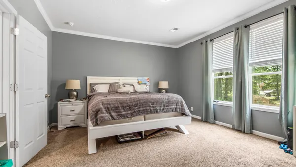 a bedroom with a bed and a large window