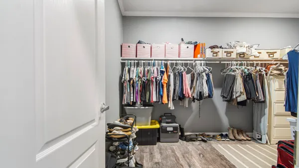 a view of walk in closet with clothes and shoes