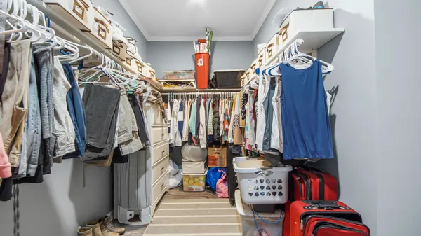 a view of walk in closet with clothes and shoes