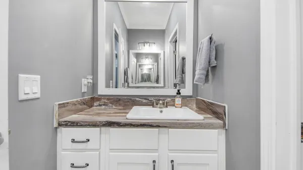 a bathroom with a granite countertop sink and a mirror