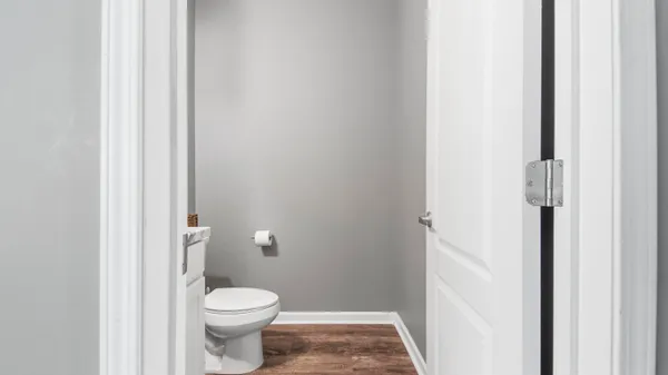 a white toilet sitting next to a white cabinet