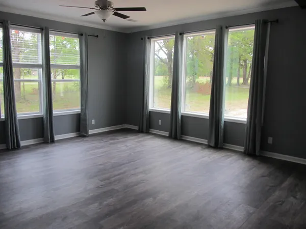 an empty room with wooden floor and balcony