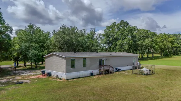 a view of a house with backyard and trees