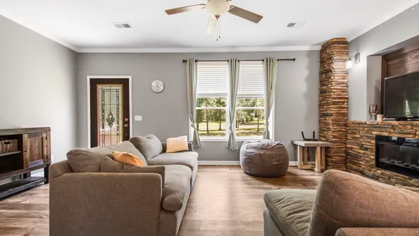 a living room with furniture a flat screen tv and a large window