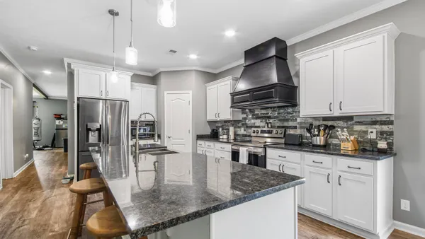 a kitchen with stainless steel appliances granite countertop a sink refrigerator and cabinets