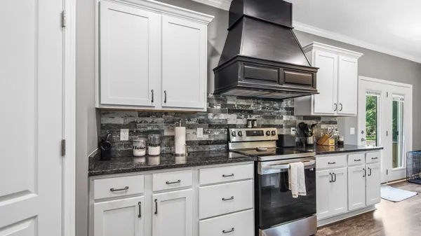 a kitchen with stainless steel appliances granite countertop a sink a stove and cabinets