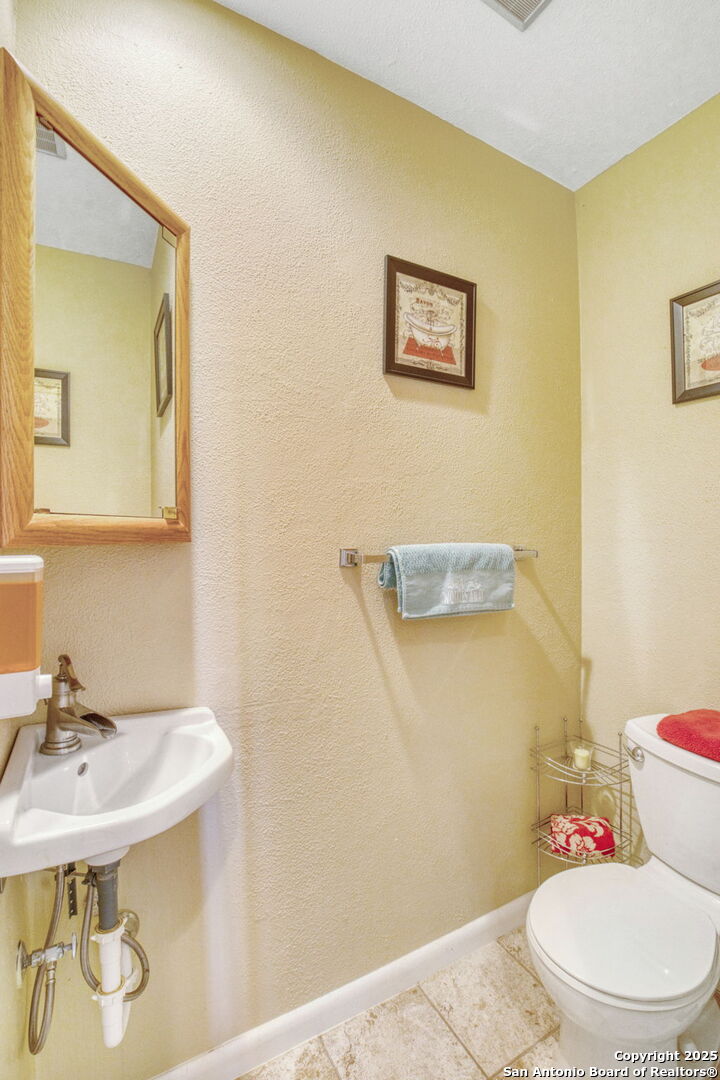 805 Highway 534 Loop, Unit 122 Kerrville, TX 78028 - Photo 17 of 30 a bathroom with a sink a toilet and mirror