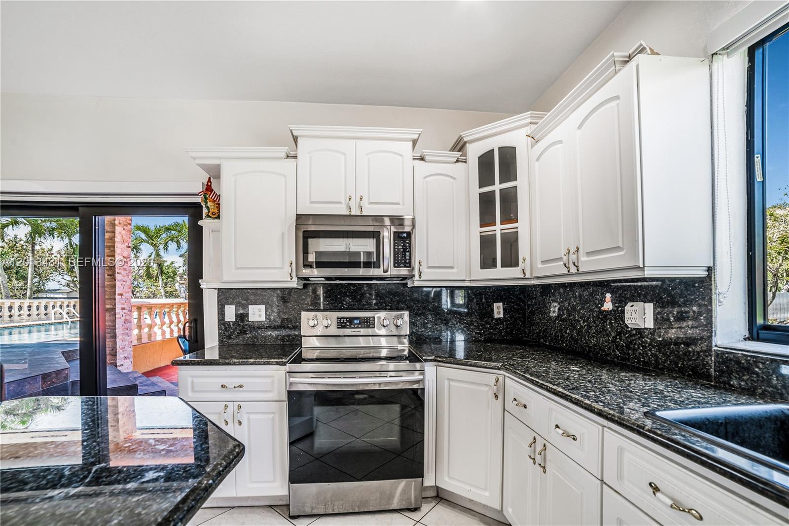 26500 Southwest 167th Avenue Homestead, FL 33031 - Photo 14 of 78 a kitchen with stainless steel appliances granite countertop a stove a sink and a microwave