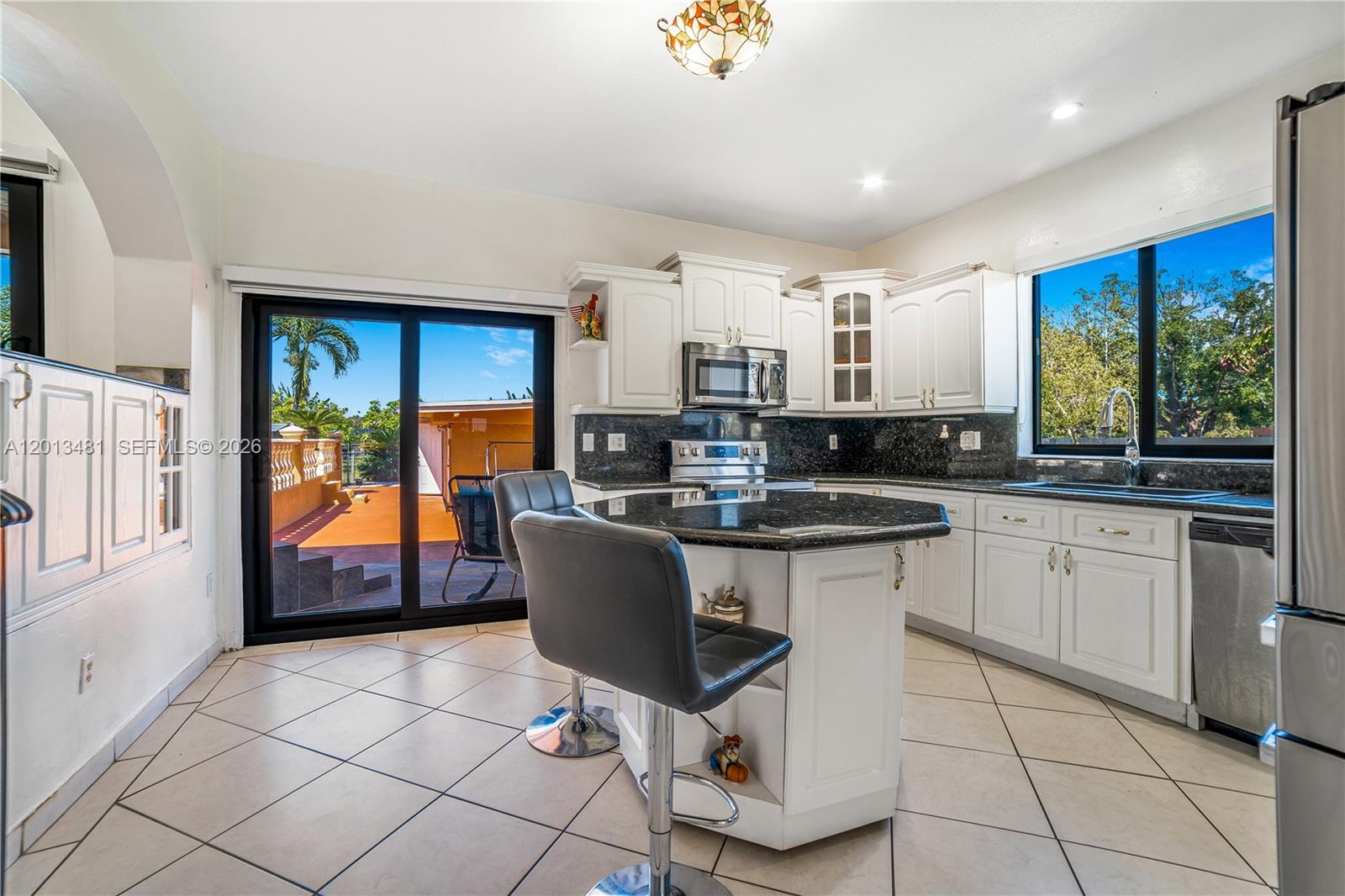 26500 Southwest 167th Avenue Homestead, FL 33031 - Photo 17 of 78 a kitchen with stainless steel appliances granite countertop a stove top oven a sink a counter space and cabinets