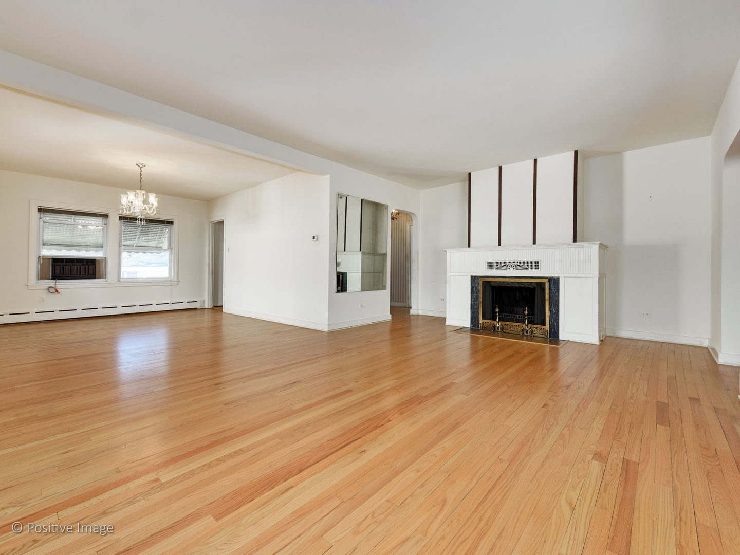 399 Longcommon Road Riverside, IL 60546 - Photo 3 of 25 an empty room with wooden floor fireplace and windows
