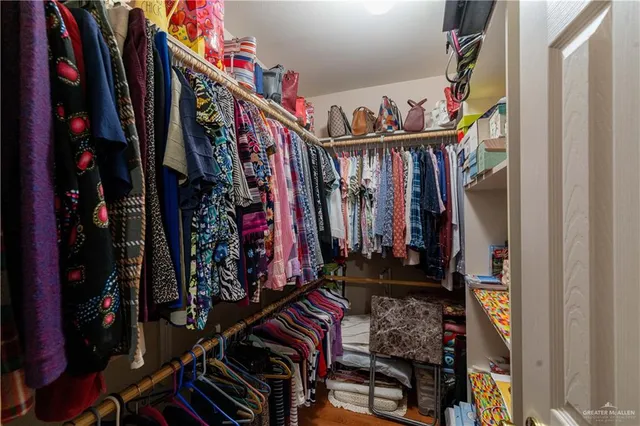 a view of walk in closet with clothes and shoes