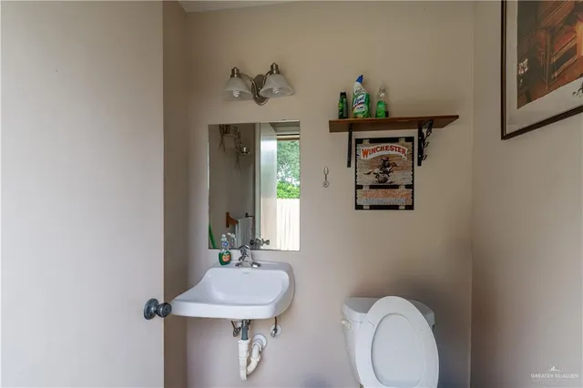 a bathroom with a toilet sink and mirror