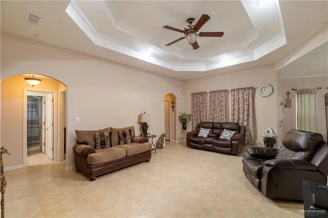 a living room with furniture and a ceiling fan