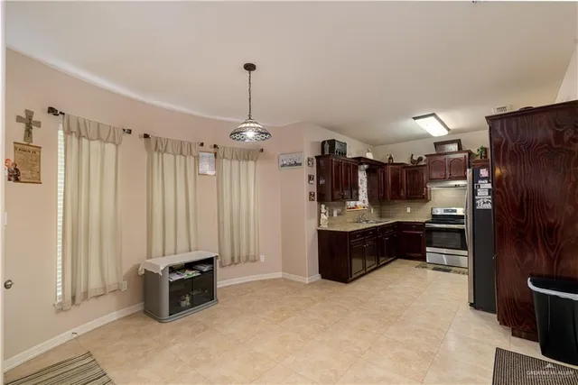 a large kitchen with a stove a refrigerator and a wooden cabinets