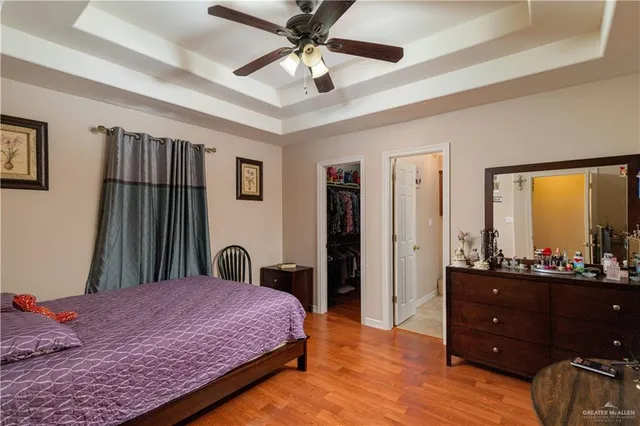 a bedroom with a bed dresser and a large window