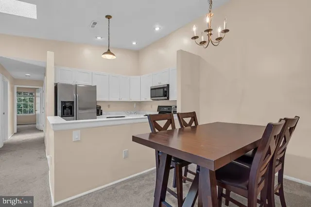 a kitchen with a dining table chairs and microwave