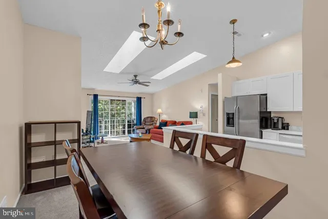 a living room with furniture a chandelier and a large window