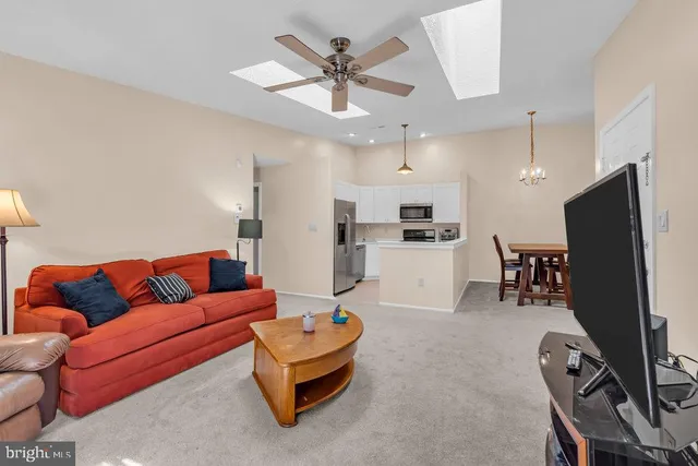 a living room with furniture kitchen view and a flat screen tv