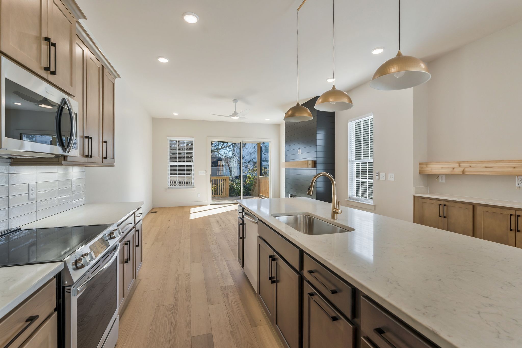 a kitchen with granite countertop a sink a counter top space stainless steel appliances and cabinets