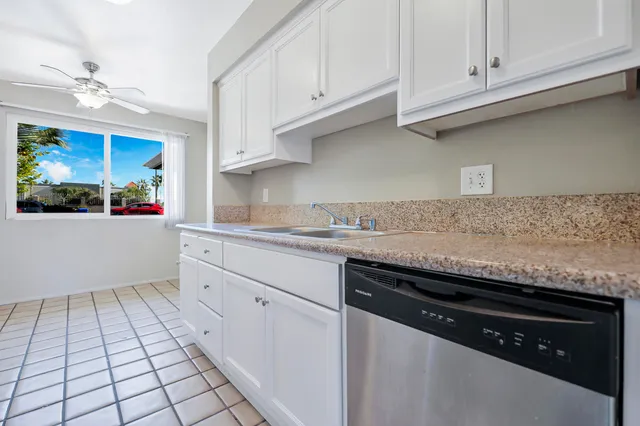 a kitchen with granite countertop white cabinets and white appliances