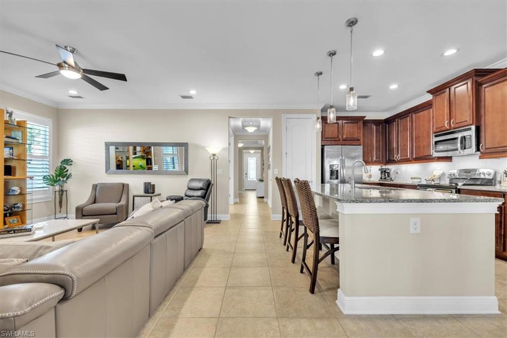 16424 Windsor Way Alva, FL 33920 - Photo 10 of 48 a large kitchen with stainless steel appliances kitchen island granite countertop a living room a stove a sink a dining table and chairs