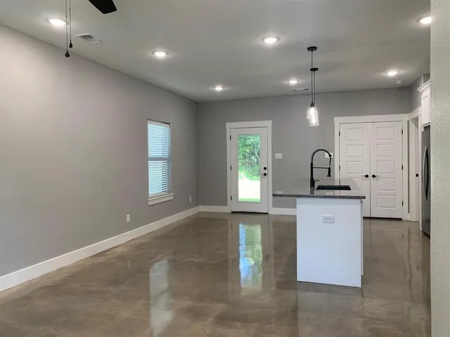 a large kitchen with kitchen island a sink stainless steel appliances and a window