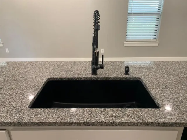 a kitchen with a sink and a stove with wooden floor