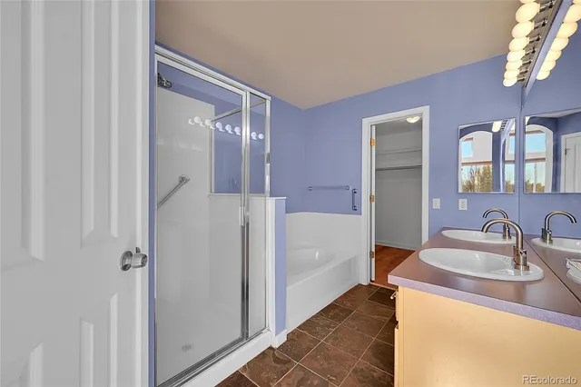 a en suite bathroom with a double vanity sink and a mirror
