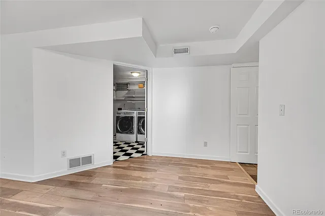 a view of a room with wooden floor and white walls