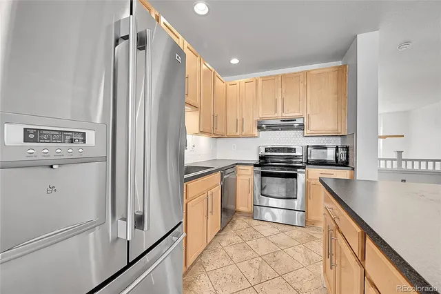 an empty room with wooden floor cabinet and windows