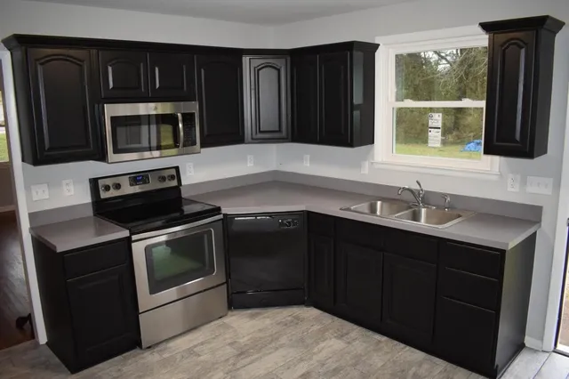 a kitchen with a sink stove and microwave