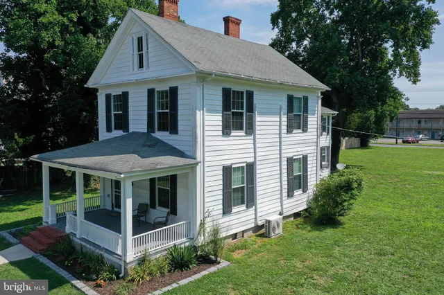 a view of a house with a yard and potted plants