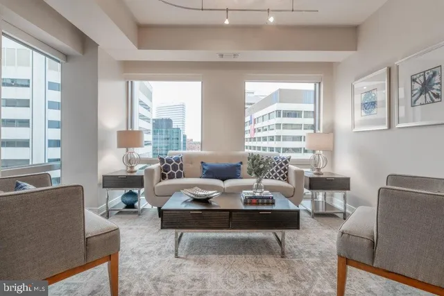 a living room with furniture and large windows