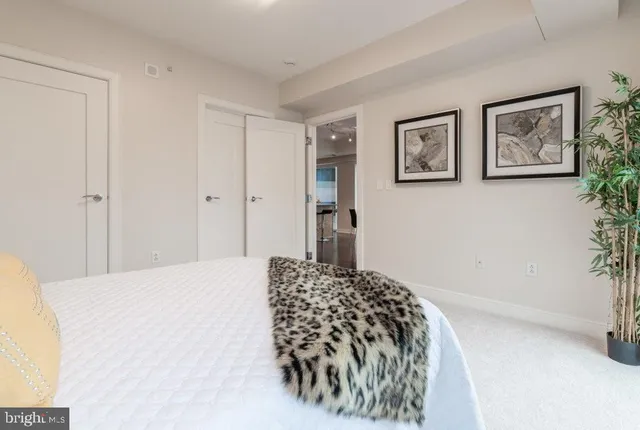 a bedroom with a bed and painting on the wall