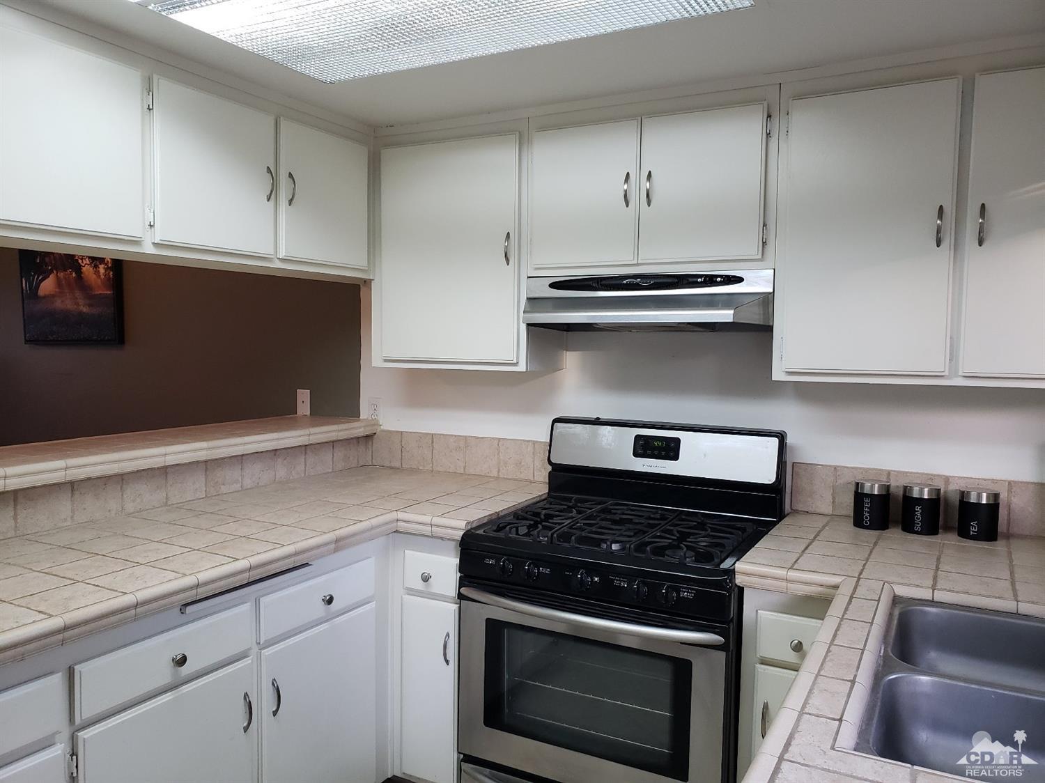 69575 Karen Way Rancho Mirage, CA 92270 - Photo 4 of 14 a kitchen with granite countertop cabinets and steel stainless steel appliances