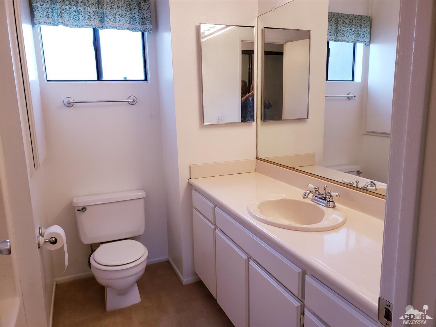 69575 Karen Way Rancho Mirage, CA 92270 - Photo 9 of 14 a bathroom with a granite countertop toilet sink and mirror