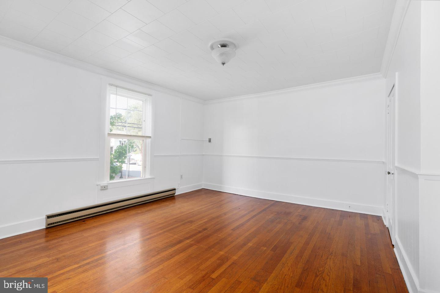 702 South Braddock Street, Unit 3 Winchester, VA 22601 - Photo 3 of 12 an empty room with wooden floor and windows