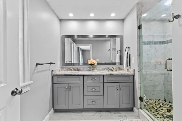 a bathroom with a granite countertop sink a large mirror and a shower