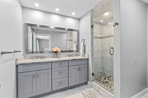 a bathroom with double sink and a mirror