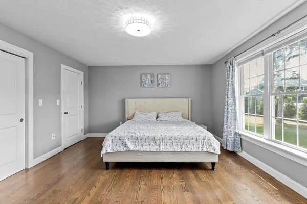 a bedroom with a bed and wooden floor