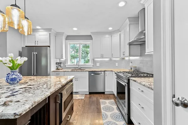 a kitchen with stainless steel appliances granite countertop a sink stove and refrigerator