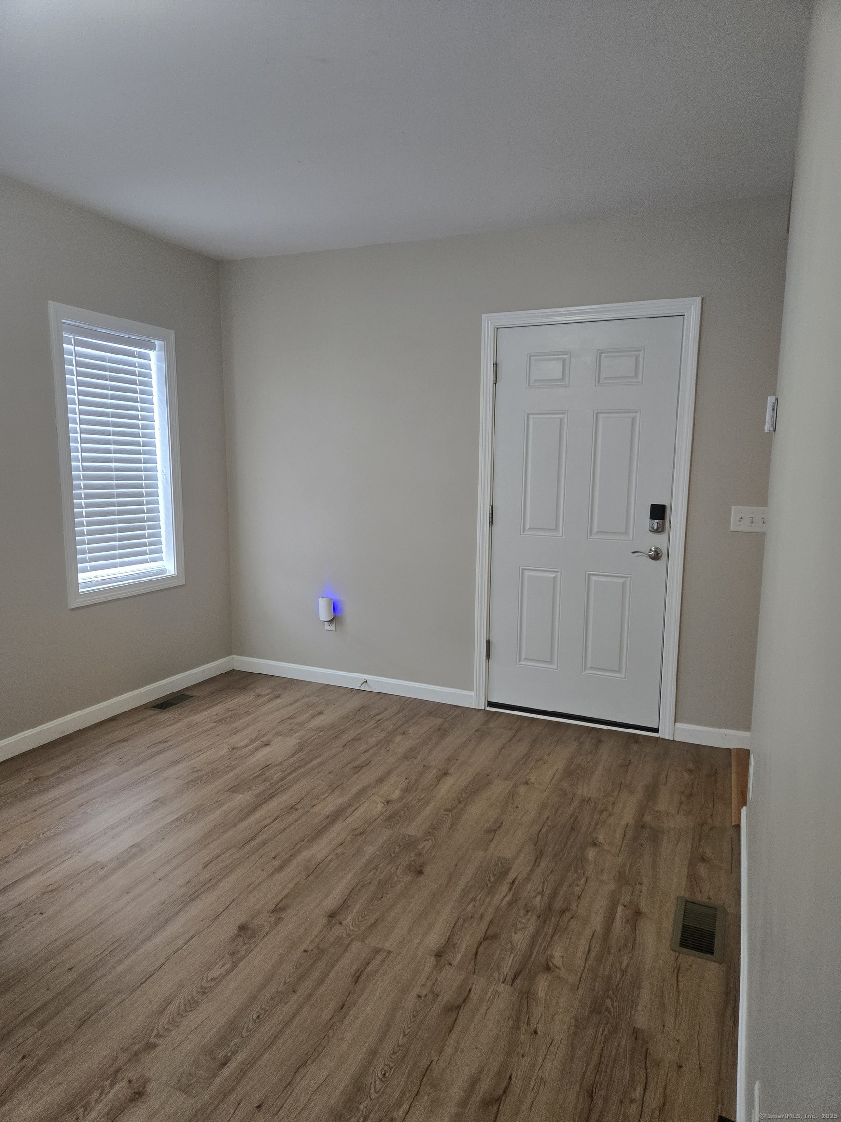 112 Liberty Street Pawcatuck, CT 06379 - Photo 13 of 22 a view of an empty room with wooden floor and a window