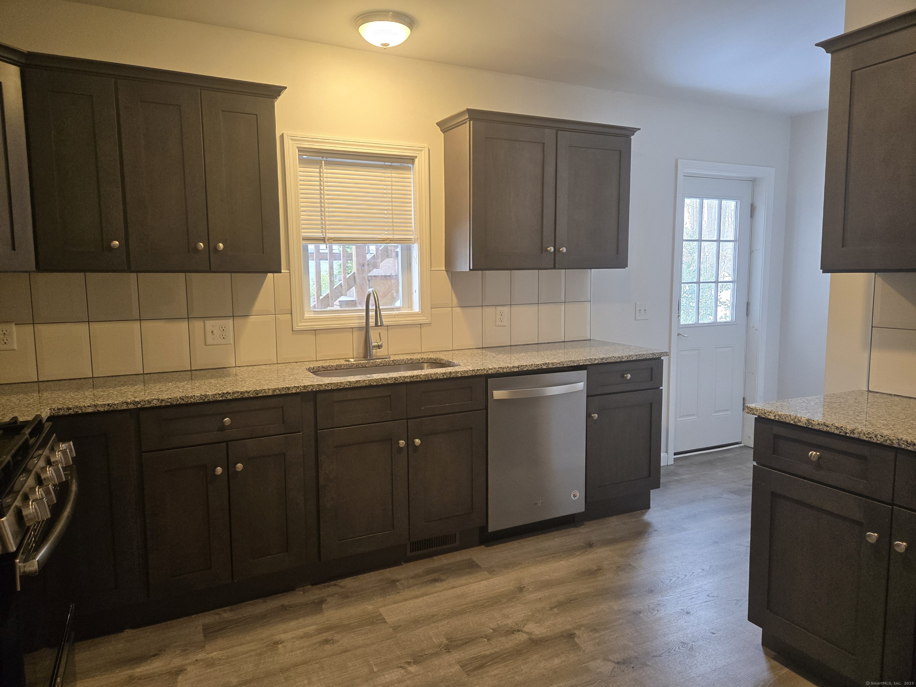 112 Liberty Street Pawcatuck, CT 06379 - Photo 6 of 22 a kitchen with sink a window and wooden cabinets