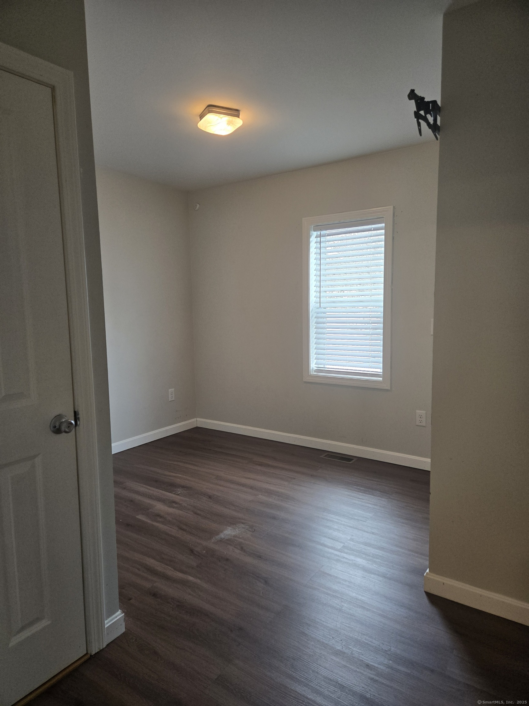 112 Liberty Street Pawcatuck, CT 06379 - Photo 10 of 22 an empty room with wooden floor and windows